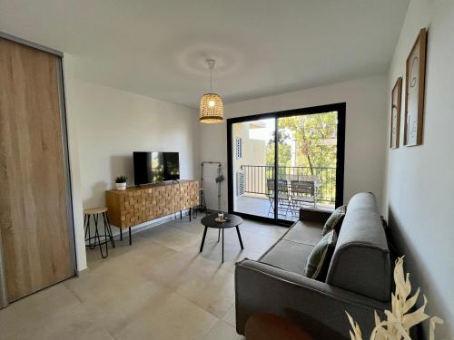 a living room with a couch and a table at Appartement climatisé neuf au calme, proche centre-ville, 4 minutes en voiture plage et commerces in Calvi