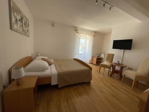 1 dormitorio con 1 cama, mesa y sillas en Apartment Parčina, en Trogir