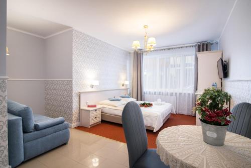 a hotel room with a bed and a chair and a table at Villa Mare in Łeba