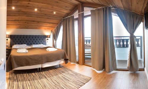 a bedroom with a bed and a large window at Predela 2 Aparthotel in Bansko