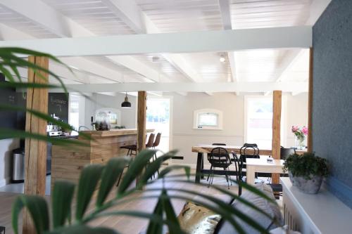 a living room with a table and chairs and a room with ceilings at Authentieke familieboerderij met sauna, tot 10 personen in Reutum