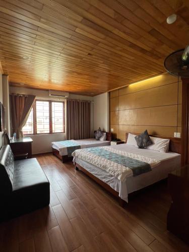 Ðoan XáにあるThanh Bình Hotelの木製の天井が特徴のベッドルーム1室(ベッド2台付)