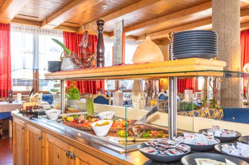a buffet line with plates and dishes on it at Apart Hotel Alpenhof Werfenweng in Werfenweng