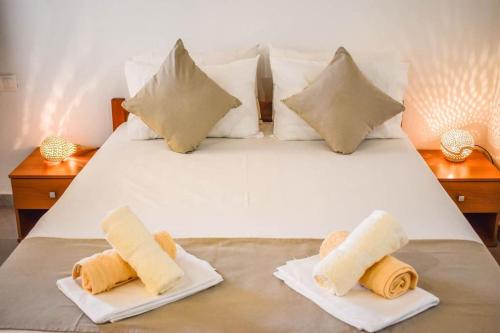 a white bed with two plates of towels on it at HUT HOUSE Εξοχικό στην παραλία Μ. Άμμος in Skiathos