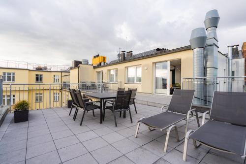 a patio with a table and chairs on a balcony at EA ApartHotel Melantrich in Prague