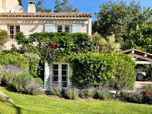 una casa con un montón de arbustos y flores en Villa Milefleure en Grimaud