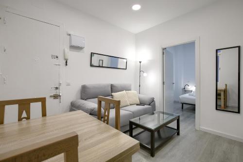 salon z kanapą i stołem w obiekcie Atocha Station - Apartamento de 2 dormitorios w Madrycie