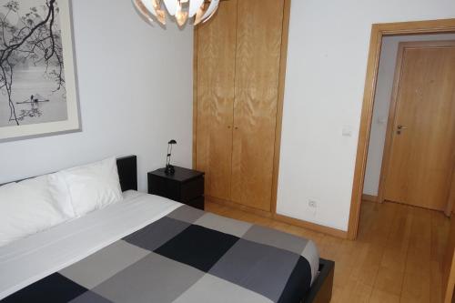 a bedroom with a black and white bed and a door at Best Apartments Portugal in Lisbon