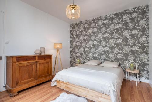 a bedroom with a bed and a black and white wallpaper at La Villa Sassolini in Lyon