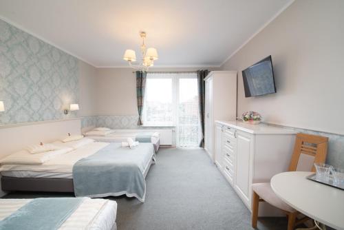 a hotel room with two beds and a table at Villa Mare in Łeba