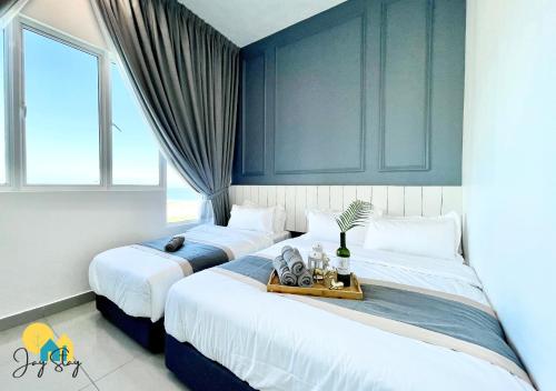 two beds in a room with blue walls at Amber Cove l Luxury Seaview 2BR l 6-8pax l GamesRoom l City Centre l Jonker St by Jay Stay in Melaka
