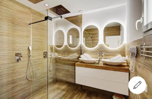 uma casa de banho com dois lavatórios e dois espelhos em L'OLYMPE DES SENS em Portiragnes