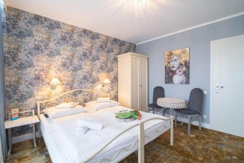a bedroom with a white bed and a desk at Villa Mare in Łeba