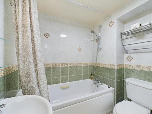 a bathroom with a white tub and a toilet at Romantic Cottage Cotswolds Parking Wi-Fi in Winchcombe