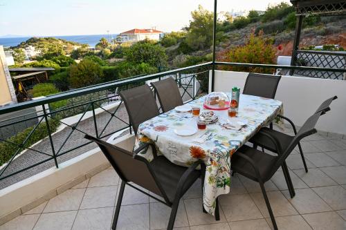 una mesa y sillas en un balcón con vistas al océano en Melrose maisonette by the sea, en Anavyssos