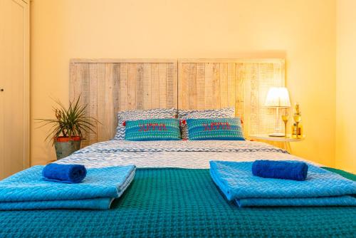 sypialnia z dużym łóżkiem z niebieskimi poduszkami w obiekcie 2 bedrooms Apt, 10 mins to SAGRADA FAMILIA w Barcelonie