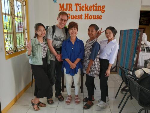 a man and a group of people standing in a room at MJR Ticketing Guest House in Ruteng