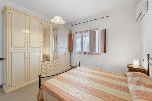 um quarto com uma cama grande e um closet em La casa Rosa em SantʼAnna Arresi