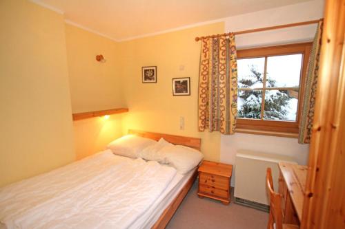 een kleine slaapkamer met een bed en een raam bij Ferienwohnung Königsleiten 210 - Top 1 in Königsleiten