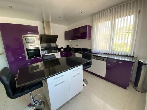 a kitchen with purple and white counters and appliances at Chez Florence Ammerschwihr in Ammerschwihr