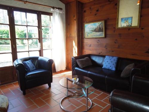 un salon avec un canapé, des chaises et une table dans l'établissement Ayllu - Hossegor villa avec piscine et barbecue, à Soorts-Hossegor