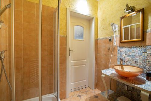 a bathroom with a sink and a shower with a bowl at Villa Mare in Łeba