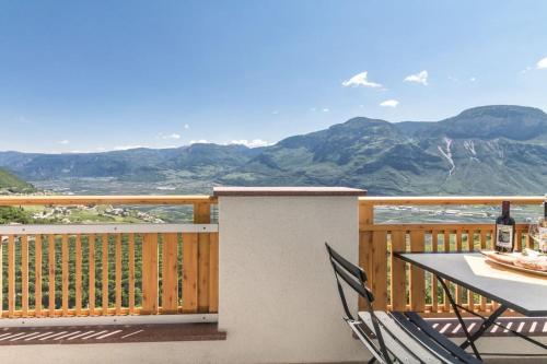 a table and chairs on a balcony with a view of mountains at Goldenhof Penon in Penone