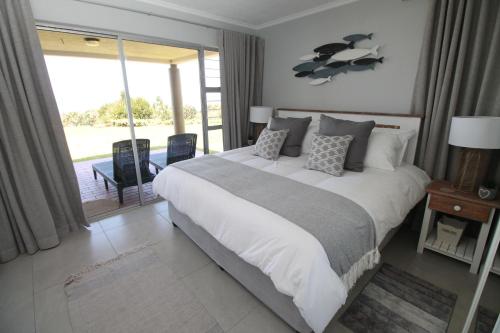 1 dormitorio con cama grande y ventana grande en Laguna La Crete 13, en Uvongo Beach