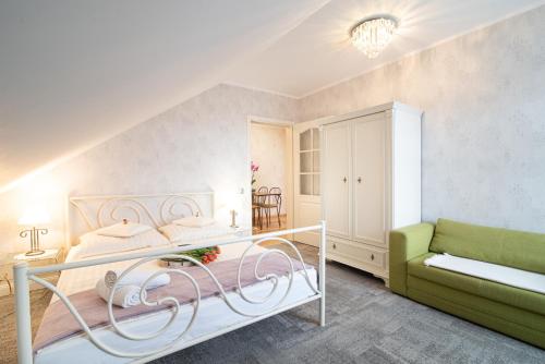 sypialnia z łóżkiem i zieloną kanapą w obiekcie Villa Mare w Łebie