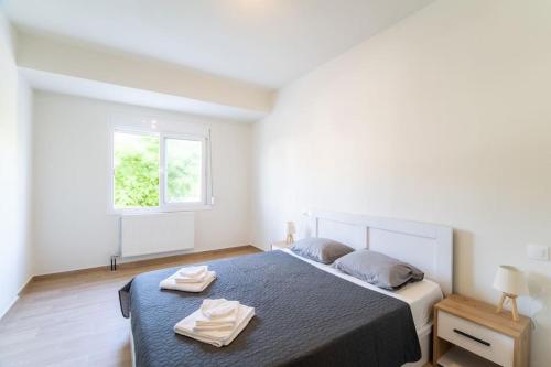 una camera da letto con un letto e due asciugamani di Volos Horizon Oasis Apartment #1 a Volos