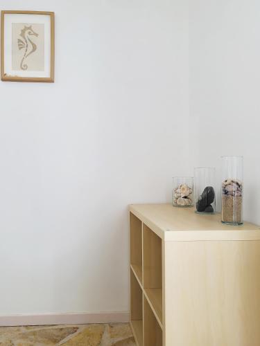 a room with a white wall and a wooden cabinet at SempreViva Sea Houses in Dhiakofti