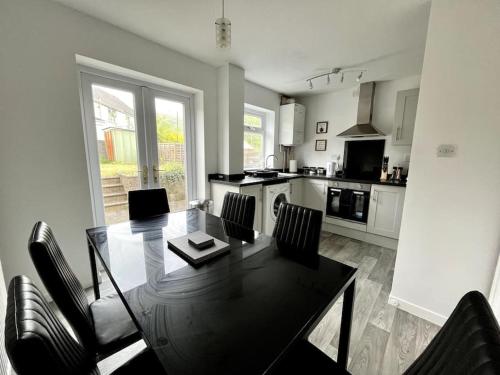 a kitchen with a dining room table and chairs at House near Swansea & Brecons! in Aberdulais