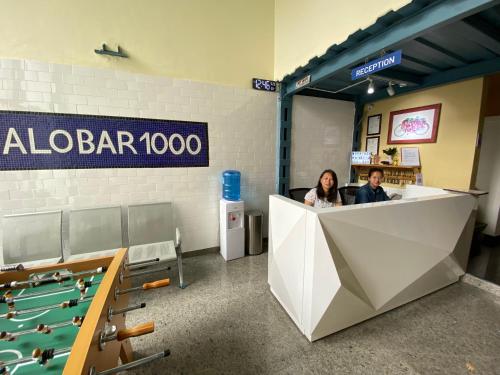 Dos personas sentadas en un bar con mesas de billar en Alobar1000 Hostel, en Katmandú