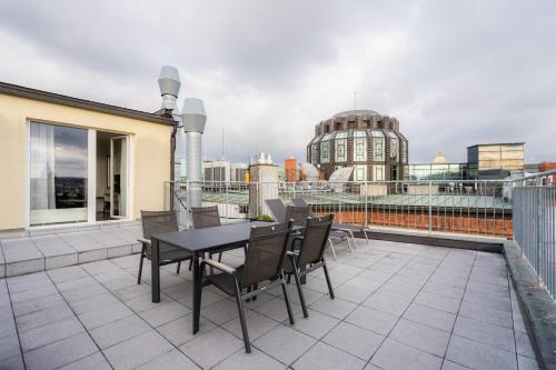 a patio with a table and chairs on a balcony at EA ApartHotel Melantrich in Prague
