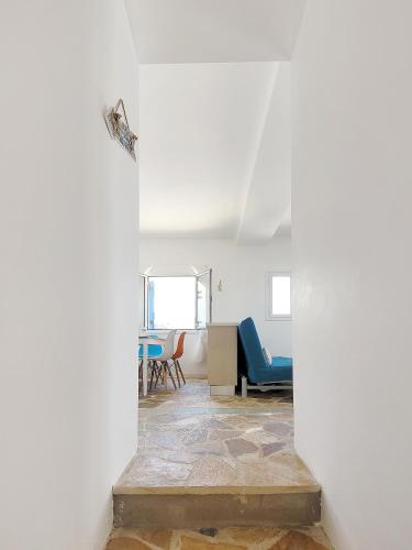 a room with a white wall and a blue chair at SempreViva Sea Houses in Dhiakofti