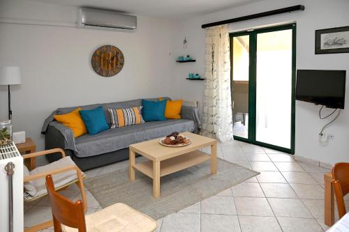 ein Wohnzimmer mit einem Sofa und einem Tisch in der Unterkunft Melrose maisonette by the sea in Anavyssos
