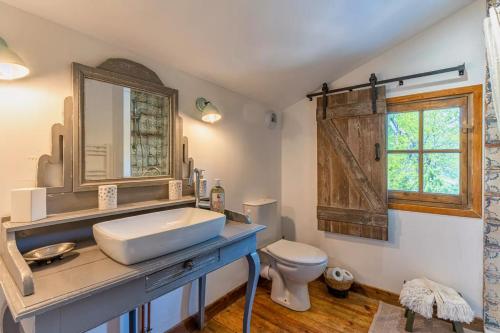 een badkamer met een wastafel en een toilet bij Domaine les Maisons des Houssats in Trensacq