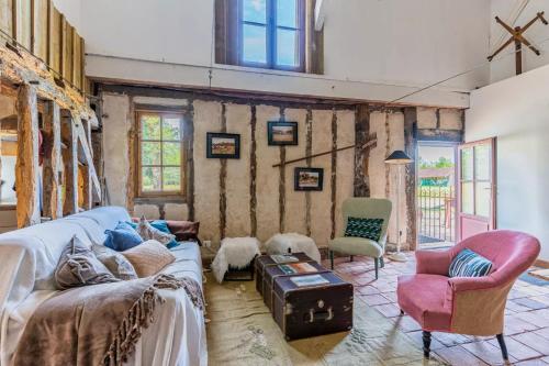 ein Wohnzimmer mit einem Sofa und 2 Stühlen in der Unterkunft Domaine les Maisons des Houssats in Trensacq