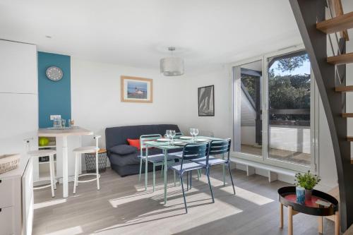 une cuisine et un salon avec une table et des chaises dans l'établissement Appartement vue mer et les pieds dans l'eau!, à Pornichet