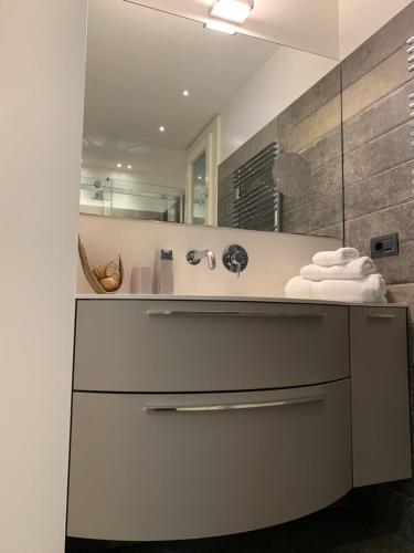 a bathroom with a sink and a mirror at AppartArbus white suite in Arbus