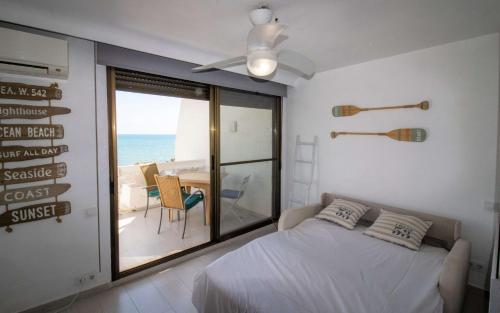 a bedroom with a bed and a view of the ocean at Atico loft en primera linea EURHOSTAL Albert Villas in Alcossebre