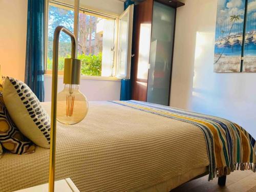 ein Schlafzimmer mit einem Bett mit einer Lampe und einem Fenster in der Unterkunft Magnifique T3 rénové, 15min à pied CV, pkg privé in Aix-en-Provence