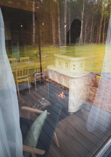 a window with a view of a deck with a fire pit at Miło las widzieć in Ciwoniuki
