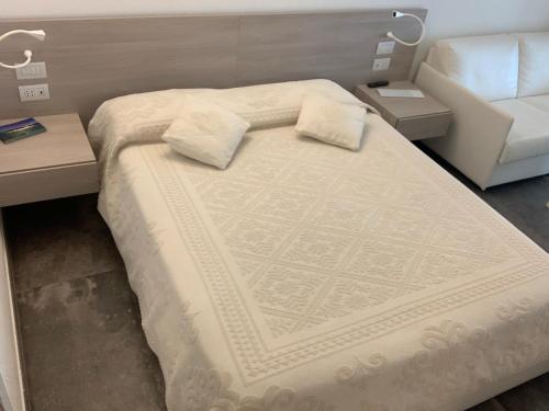 a bed with two pillows on it in a room at AppartArbus white suite in Arbus