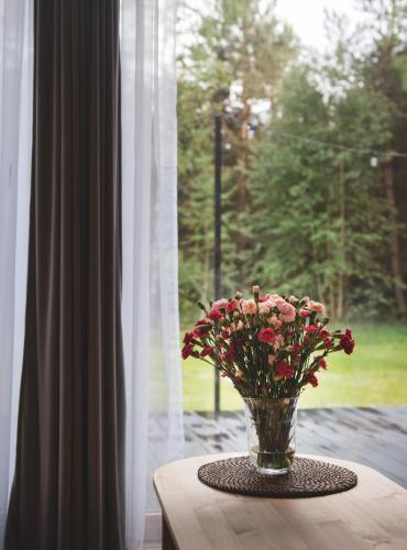 a vase of flowers sitting on a table in front of a window at Miło las widzieć in Ciwoniuki