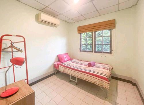 Kleines Zimmer mit einem Bett und einem Fenster in der Unterkunft Village House CAC 2 in Strand Bang Tao