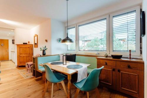 cocina con mesa, sillas y ventanas en Chalet-Apartment Seefeld and Chill HARMONY im Zentrum mit Netflix for free, en Seefeld in Tirol
