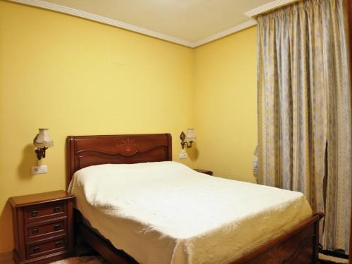 トレビエハにあるPurisimaのベッドルーム1室(黄色い壁、ベッド1台、窓付)
