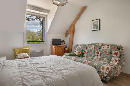 une chambre avec un lit, un canapé et une fenêtre dans l'établissement Piscine ! Maison pour 9, à Saint-Nazaire