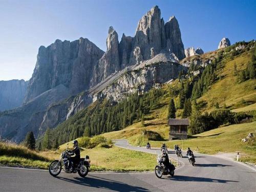 a group of motorcycles driving down a road in the mountains at Fedaia Joy B&B in Canazei